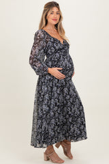 woman wearing a black floral long sleeve maternity dress with a baby bump visible