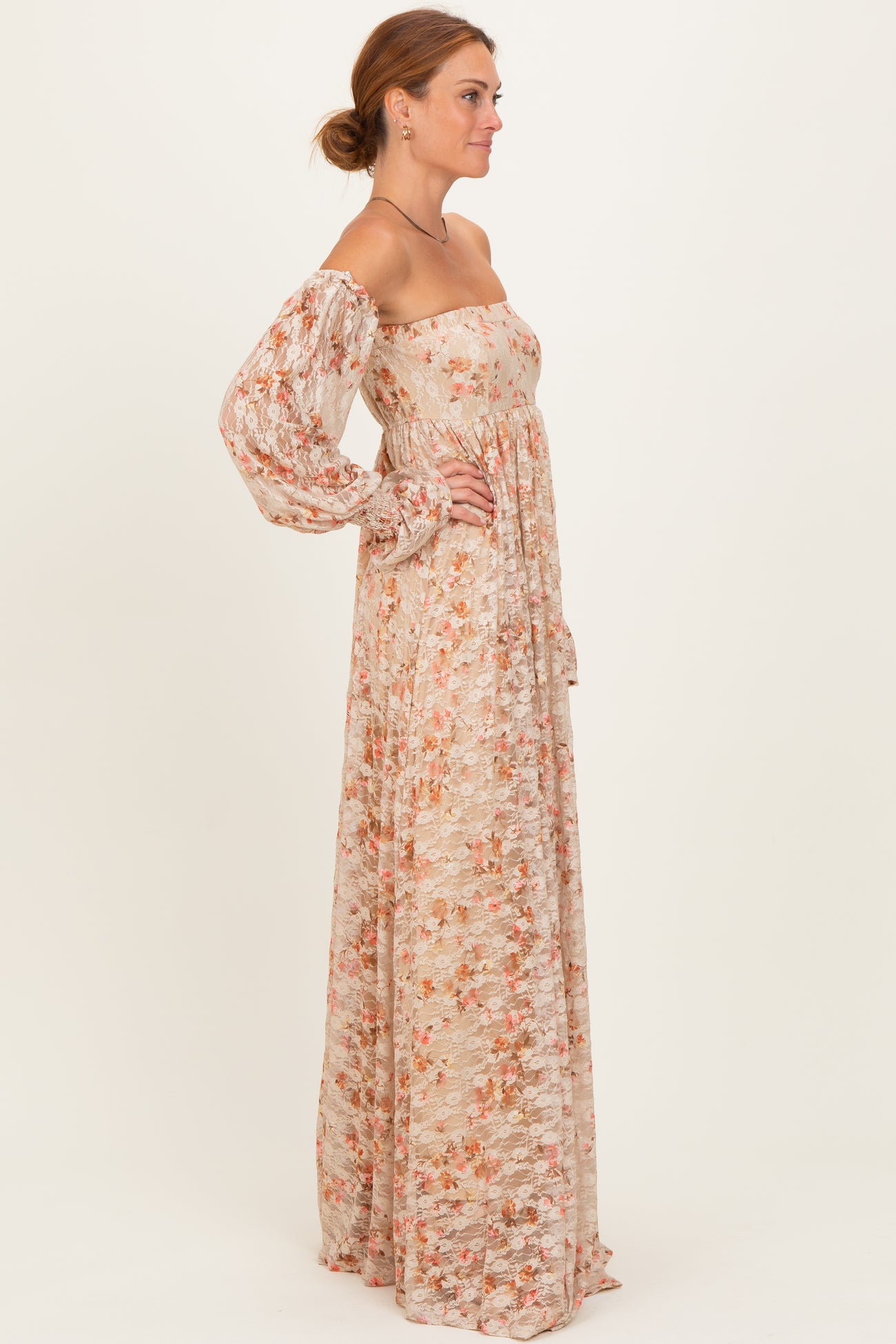 woman wearing a long floral maxi dress with puff sleeves, featuring a strapless neckline and a flowy silhouette