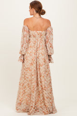 woman wearing a floral off-shoulder maxi dress with long sleeves and a cinched waist, viewed from the back