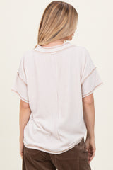 woman wearing a light pink ribbed short sleeve top, viewed from the back
