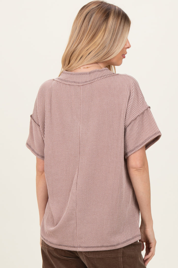 woman wearing a mauve short sleeve oversized ribbed top with a relaxed fit and a round neckline