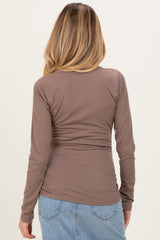 woman wearing a brown long sleeve maternity top, viewed from the back, with a fitted style and ribbed texture