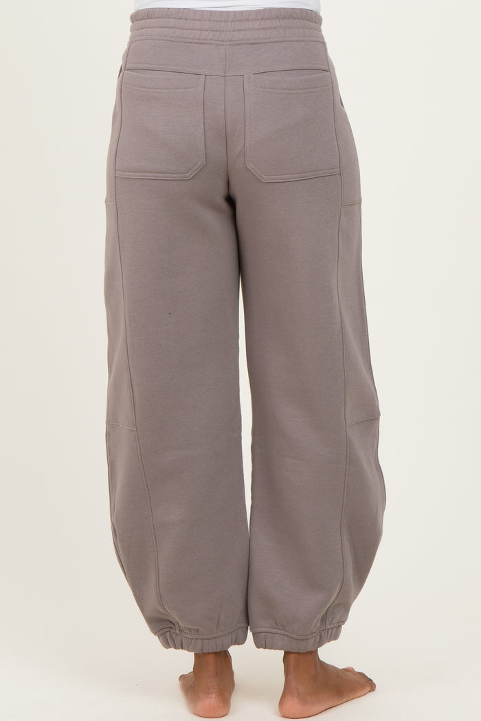 woman wearing light gray maternity sweatpants with elastic cuffs and side pockets, seen from the back