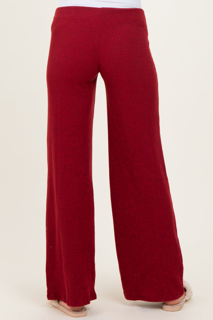 woman wearing red ribbed maternity pants with a wide-leg style, shown from the back