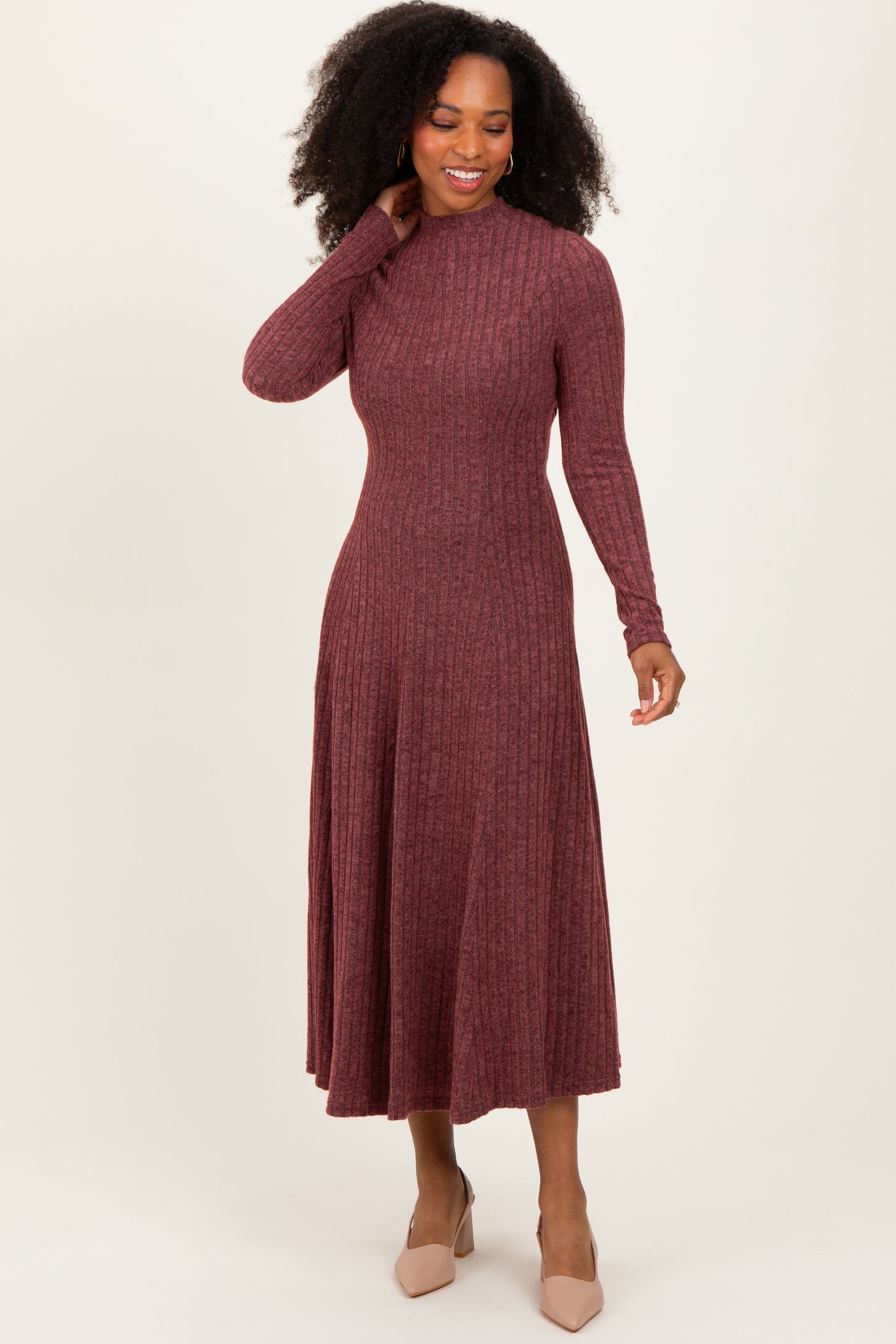 woman wearing a burgundy ribbed long sleeve midi dress and beige heels