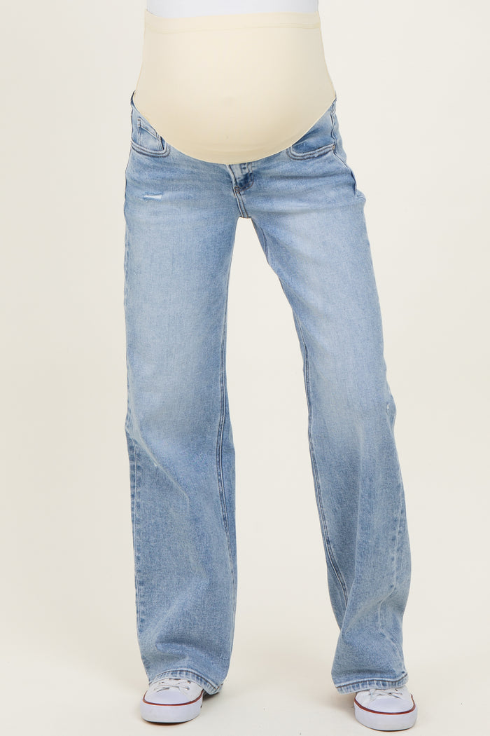 woman wearing light blue maternity jeans with a stretchy beige panel for belly support