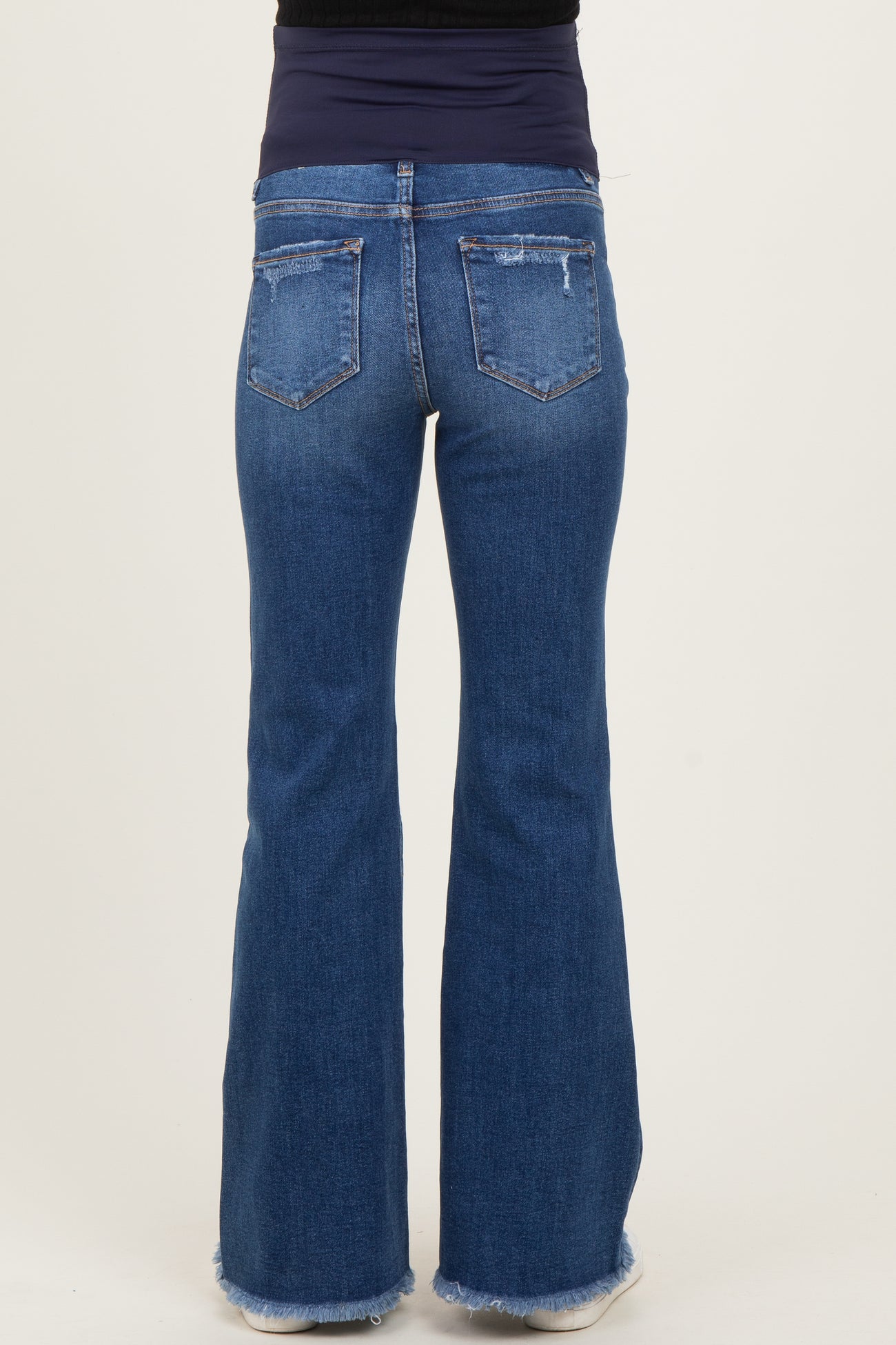 maternity wear light wash flared jeans with a distressed hem, worn by a model with a fitted top
