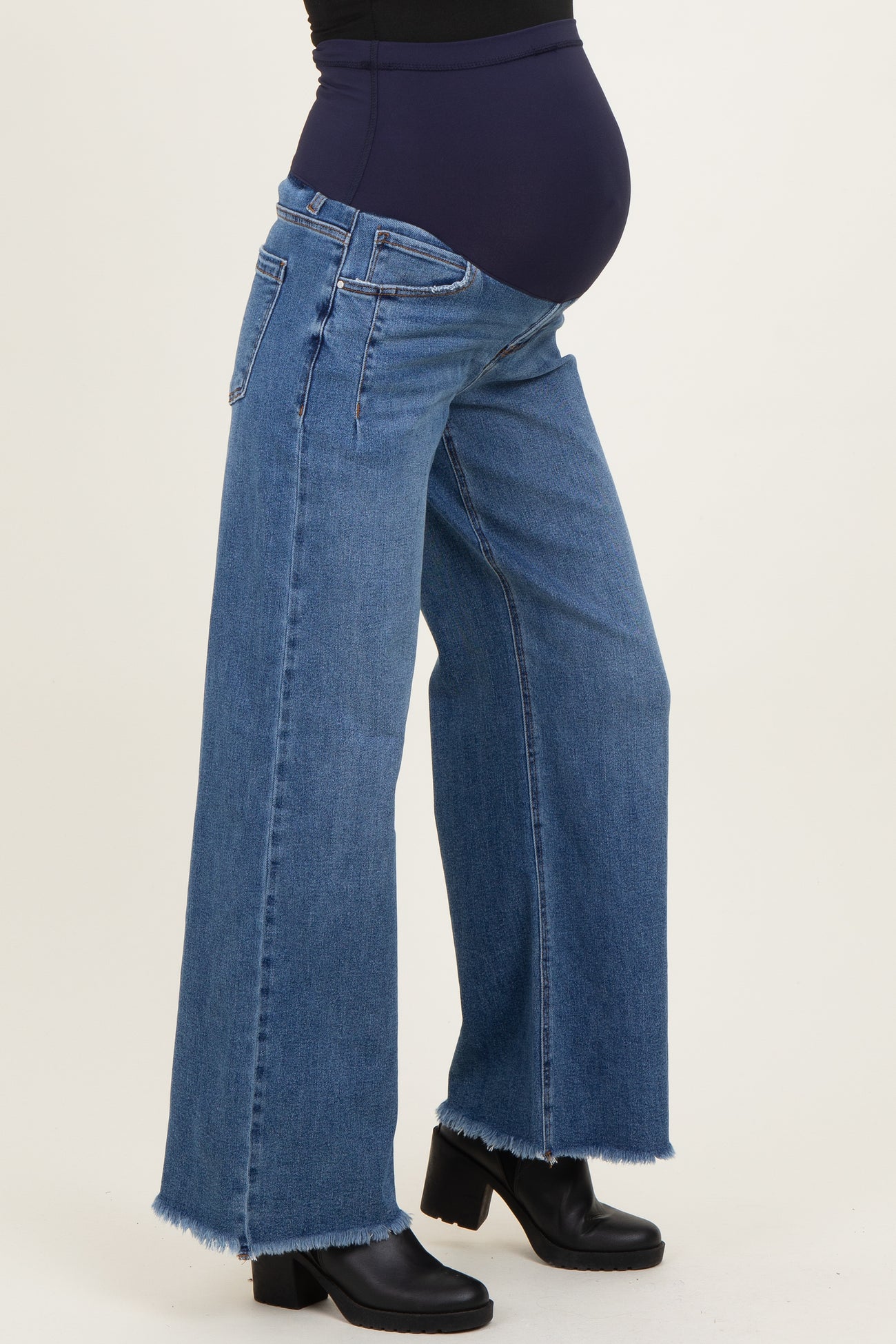 maternity wear blue wide-leg jeans with a high waistband, model showing baby bump while wearing black heeled boots