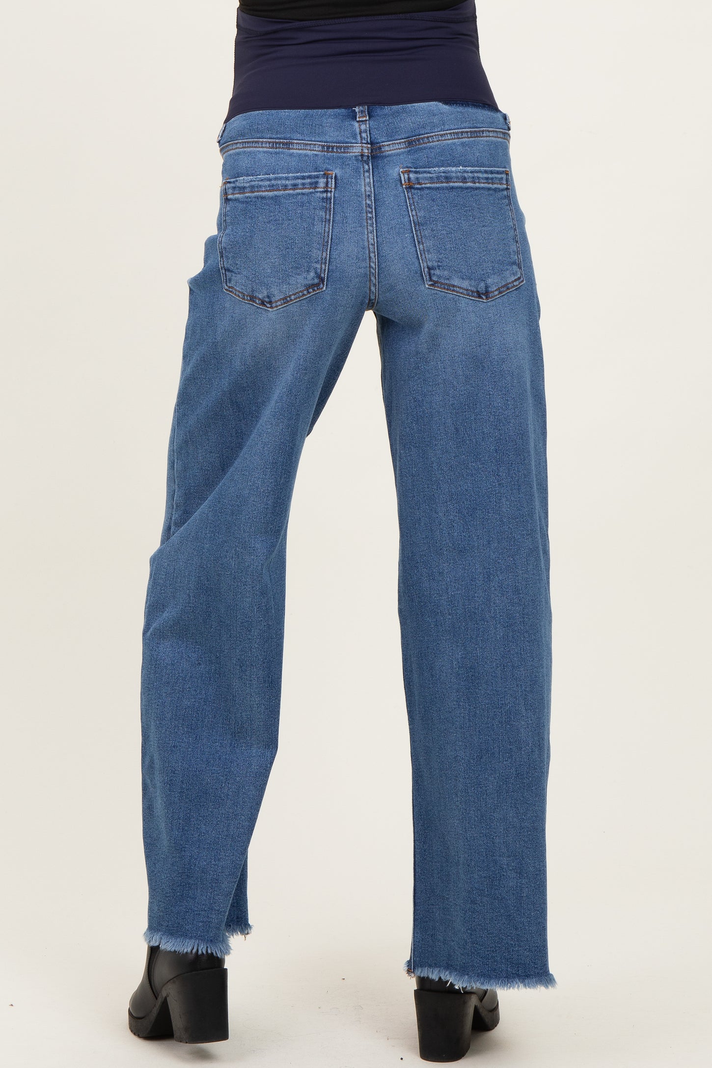 maternity wear blue high-waisted jeans with a relaxed fit and raw hem detail, model shown from the back