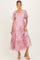 woman wearing a pink floral maternity dress with puff sleeves and a tiered skirt