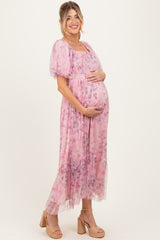 woman wearing a pink floral maternity dress with puff sleeves and holding her baby bump