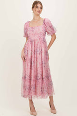 woman wearing a pink floral maxi dress with puff sleeves and ruffled hemline