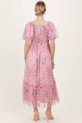 woman wearing a pastel pink floral maxi dress with puff sleeves and a smocked bodice, shown from the back