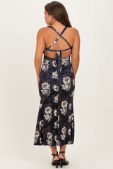 woman wearing a navy floral print maternity dress with a flared skirt and crisscross back straps