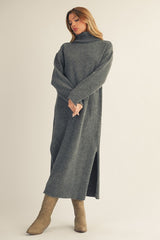 woman wearing a long gray turtleneck sweater dress with side slits and beige knee-high boots