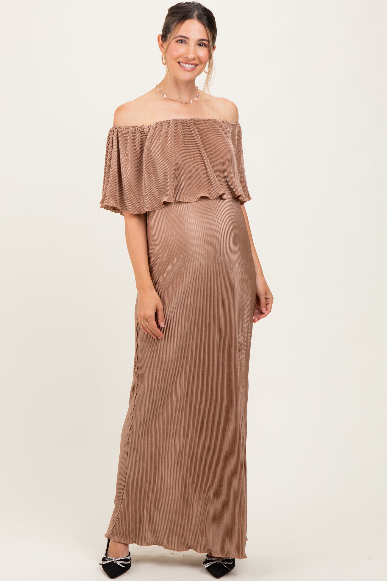 woman wearing a brown off-the-shoulder pleated maternity gown showcasing her baby bump