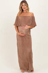 woman wearing a brown off-shoulder maternity dress with ruffle detailing and holding her baby bump
