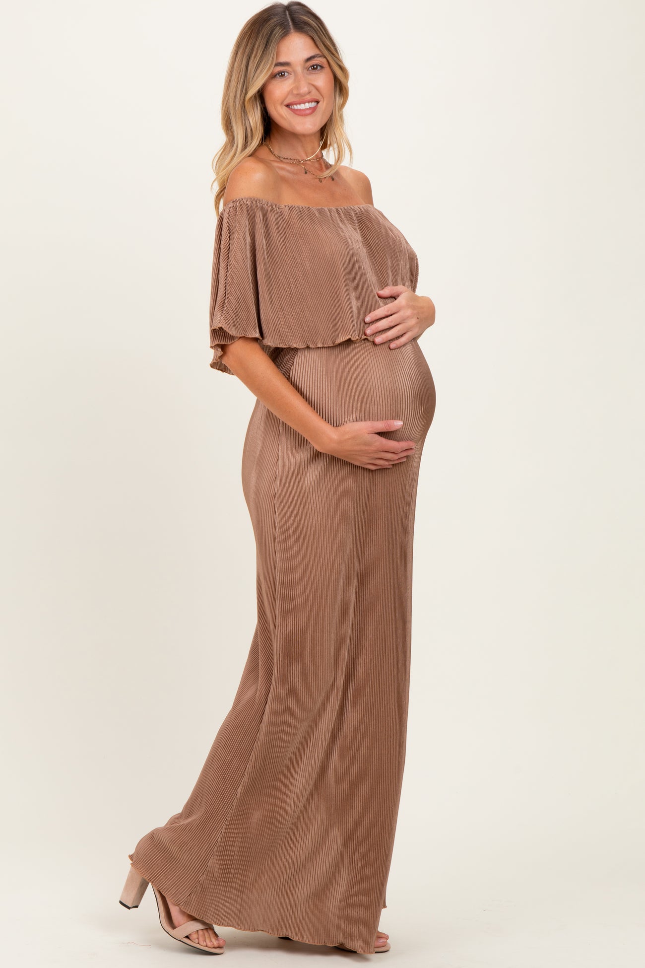 woman wearing a brown off-the-shoulder ribbed maternity dress and holding her baby bump