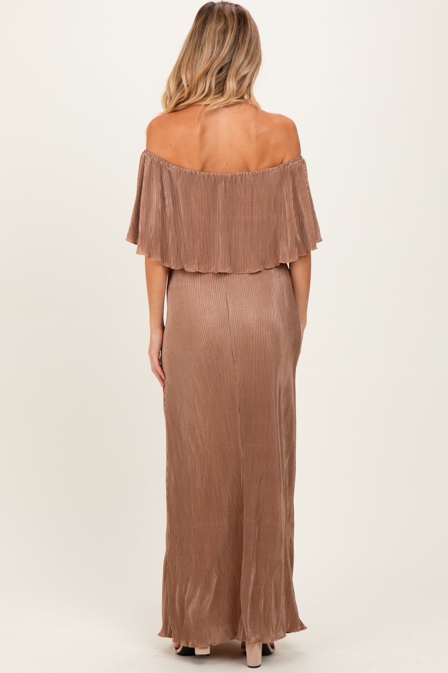 woman wearing a rose gold off-the-shoulder maternity dress with a pleated design and a flowing silhouette from the back