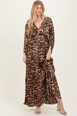 woman wearing a leopard print maxi dress with a deep v-neck and long sleeves, standing against a neutral background