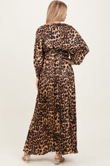 woman wearing a long leopard print maxi dress with gathered waist and long sleeves, view from the back