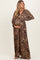woman wearing a leopard print maternity maxi dress and holding her baby bump
