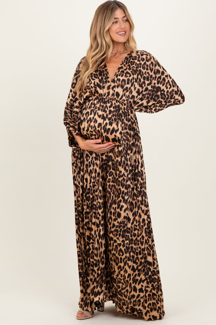 woman wearing a leopard print maternity maxi dress and holding her baby bump