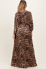 woman wearing a leopard print maternity maxi dress with long sleeves and a tied waist, showing her baby bump