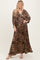 woman wearing a leopard print maxi dress with a deep V-neck and flowing sleeves
