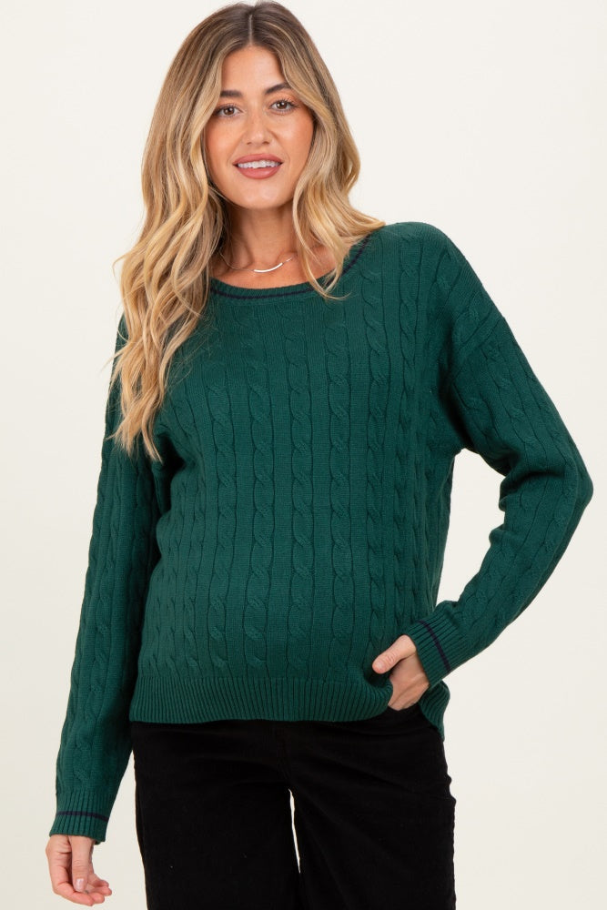 woman wearing a dark green cable knit maternity sweater with a relaxed fit and a visible baby bump