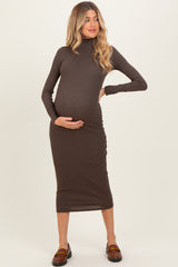 woman wearing a brown long sleeve maternity dress, highlighting her baby bump