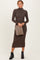 woman wearing a brown long sleeve turtleneck midi dress and holding a leopard print clutch bag