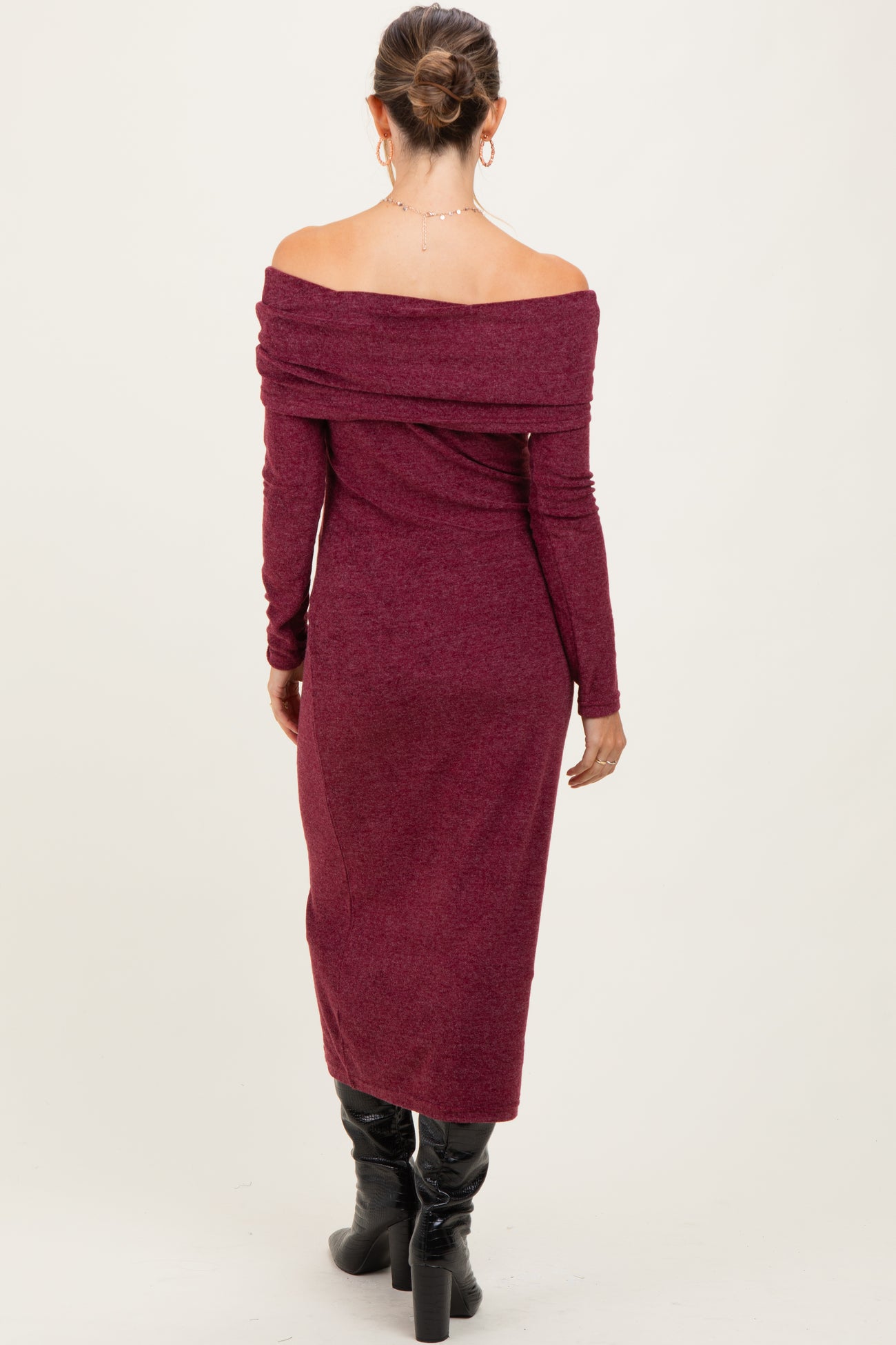 woman wearing a burgundy off-shoulder long sleeve maternity dress, showing a baby bump from the back