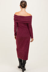 woman wearing a burgundy off-shoulder long sleeve maternity dress, showing a baby bump from the back