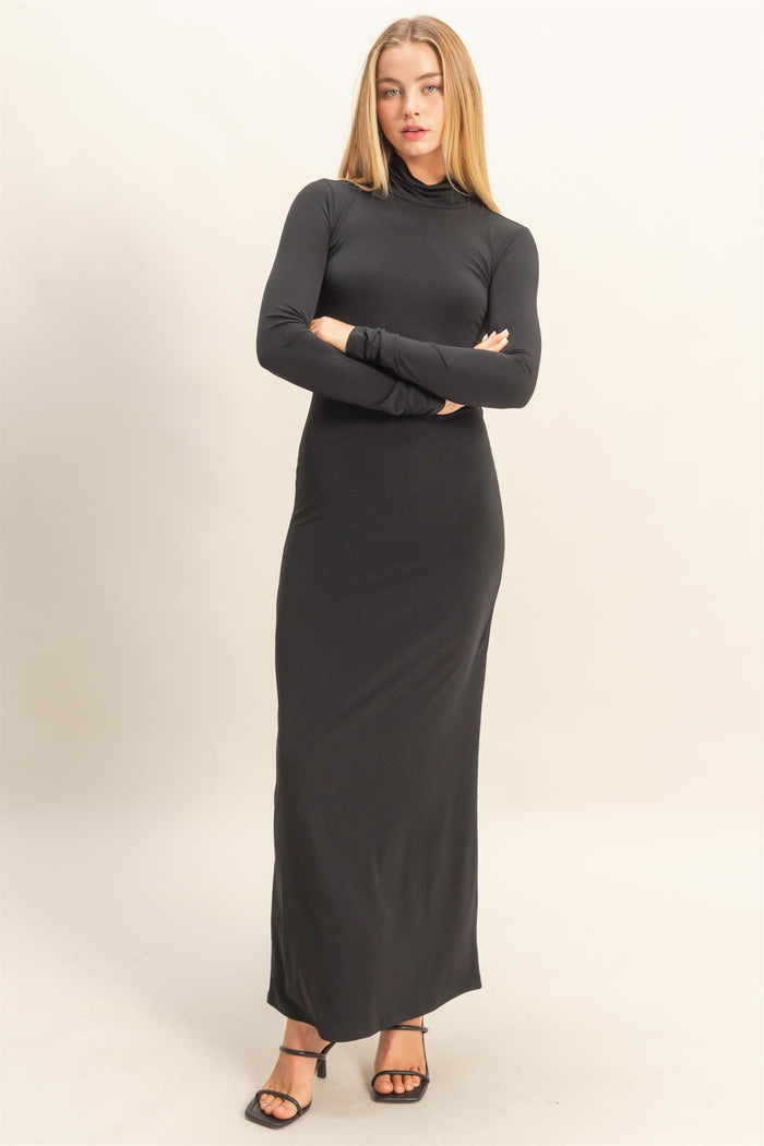 woman wearing a fitted black long sleeve maxi dress with a high neck and sleek silhouette