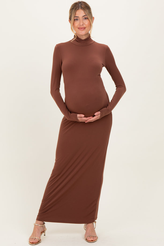 woman wearing a brown long sleeve maternity dress and holding her baby bump