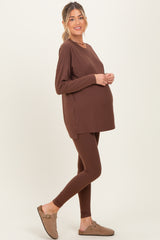 woman wearing a brown maternity long sleeve top and brown leggings, showcasing a baby bump