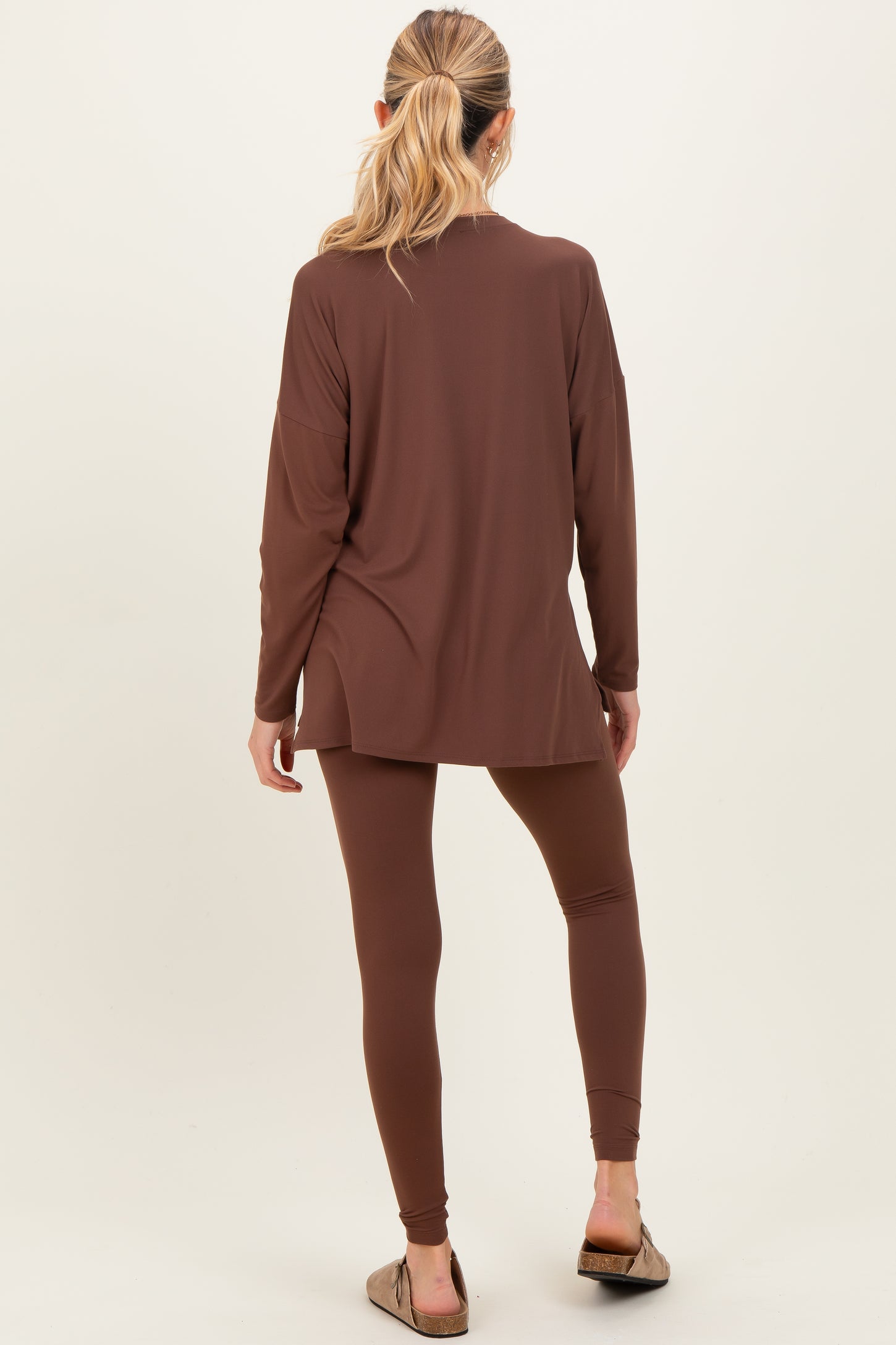 woman wearing a brown maternity top and matching leggings, showing a relaxed fit and comfortable style