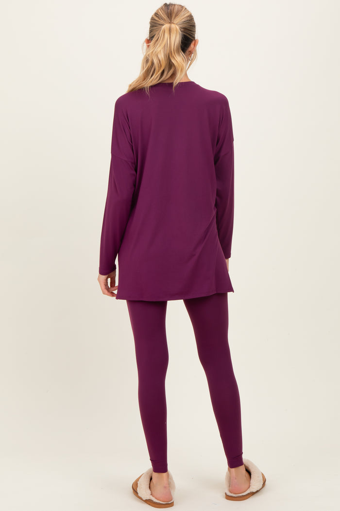 woman wearing a long sleeve purple maternity tunic and matching leggings, facing away with a relaxed style