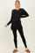 woman wearing a black long sleeve maternity top with leggings and cozy slippers, showing a baby bump
