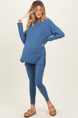 woman wearing a blue long sleeve maternity top and matching leggings, highlighting her baby bump