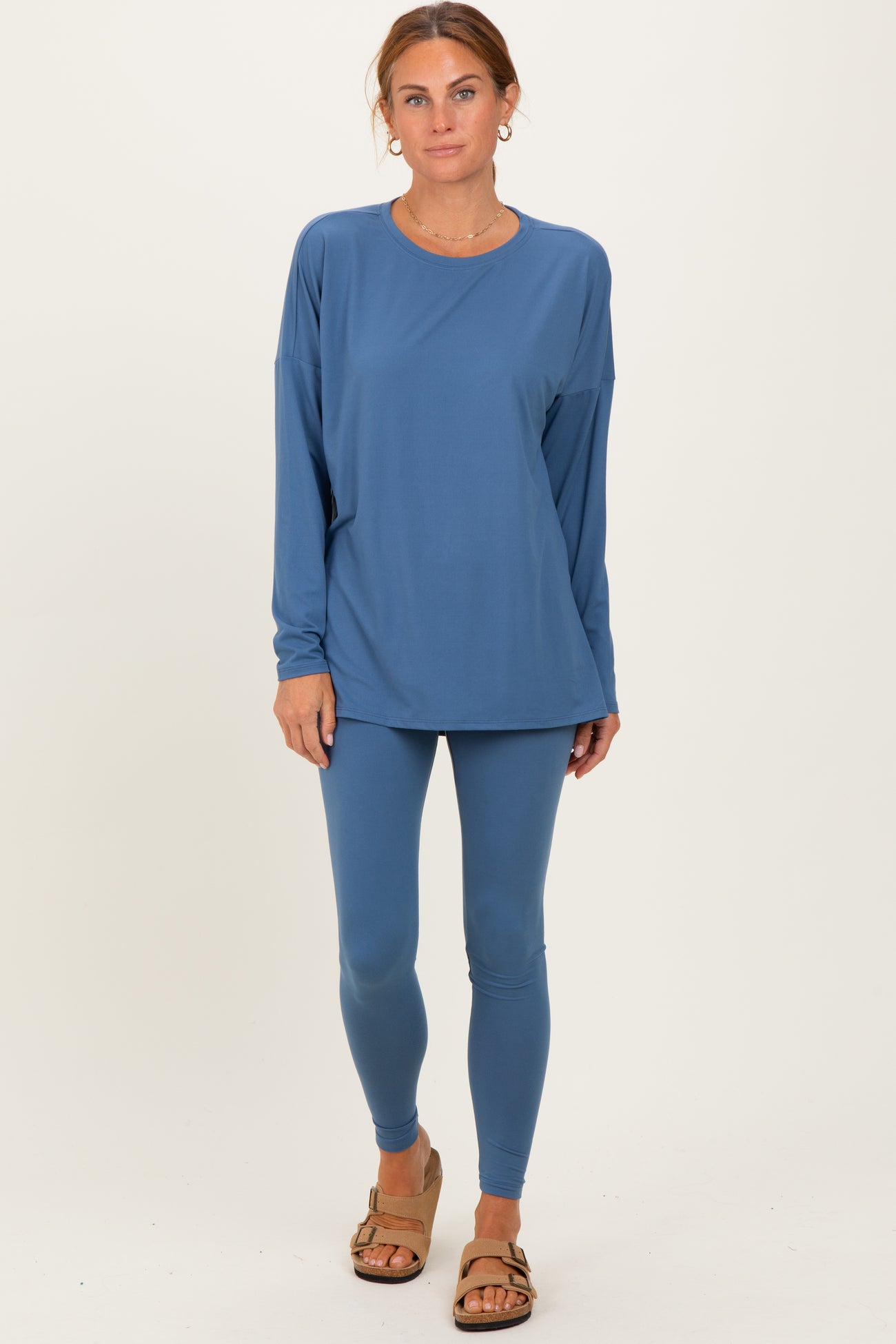 woman wearing a long sleeve blue athletic top and matching blue leggings