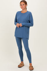 woman wearing a relaxed fit blue long sleeve top and matching leggings with brown slide sandals