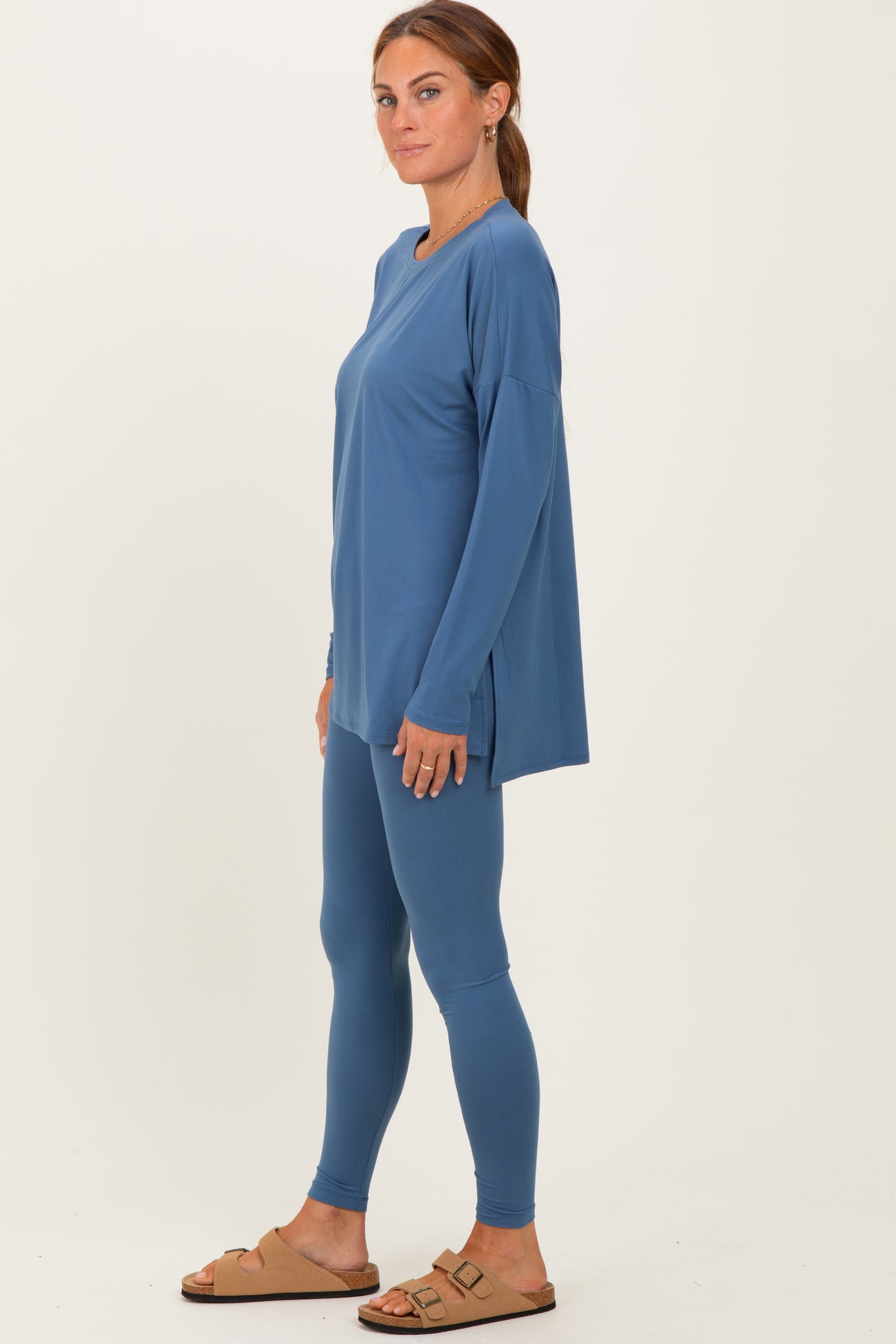 woman wearing a long sleeve blue top with side slits and matching leggings, stylish and comfortable outfit