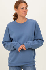 woman wearing a blue crewneck sweatshirt with dropped shoulders and long sleeves, styled with casual jeans