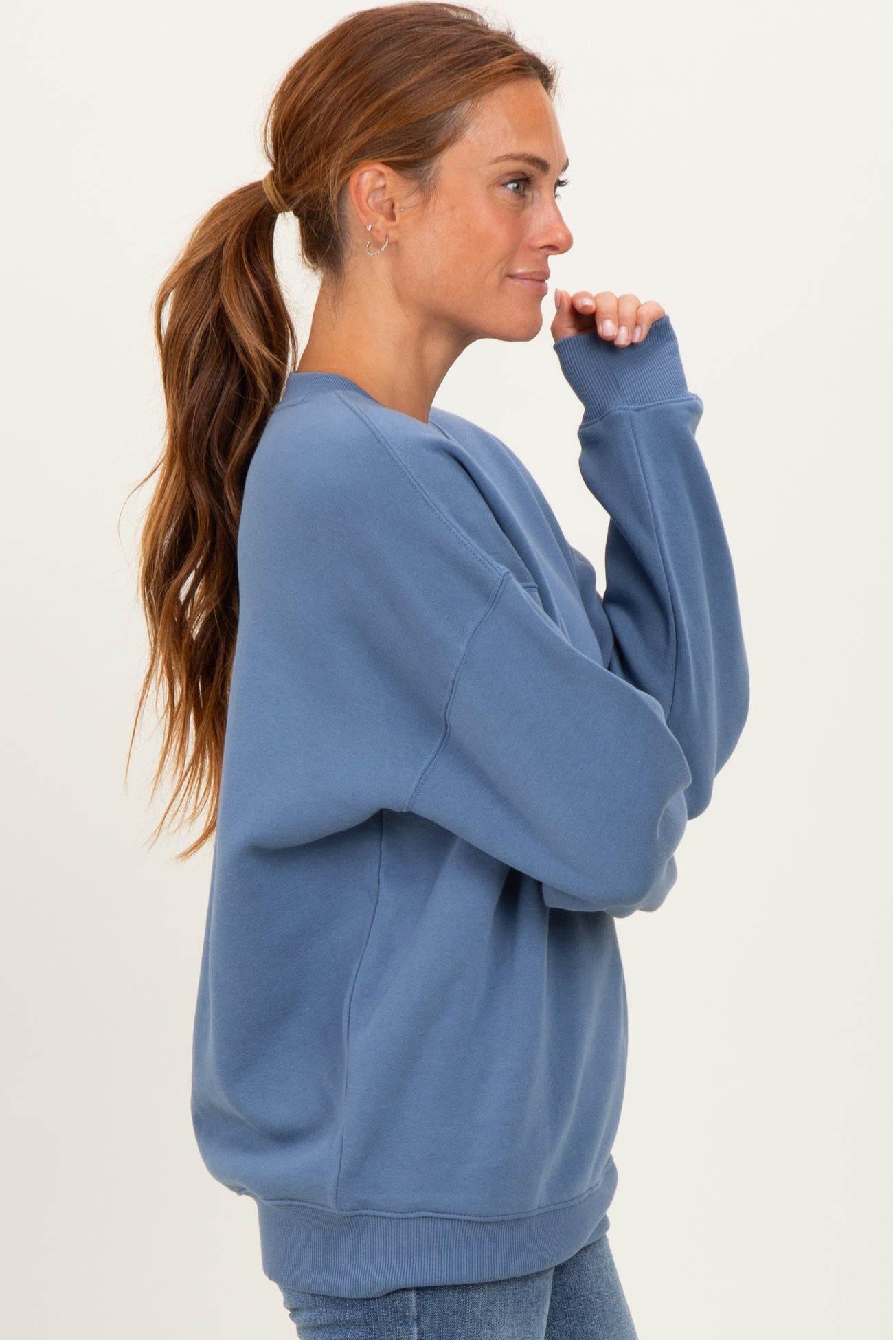 woman wearing a relaxed fit light blue sweatshirt with long sleeves and a crew neck