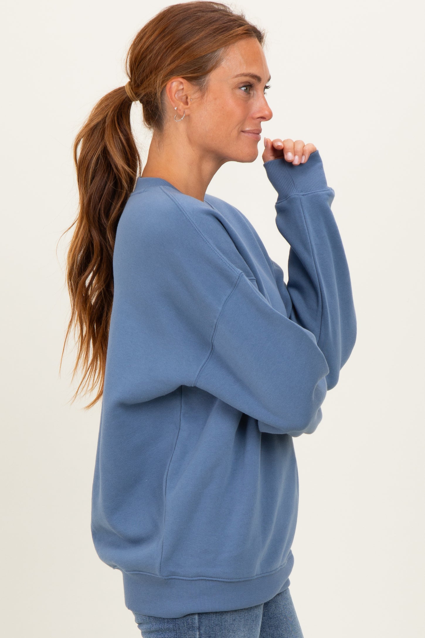 woman wearing a relaxed fit light blue sweatshirt with long sleeves and a crew neck