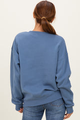 woman wearing a blue oversized sweatshirt with a relaxed fit and long sleeves, viewed from the back