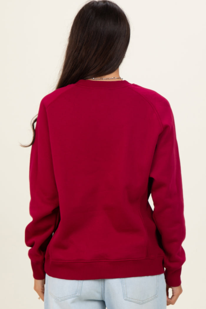 woman wearing a burgundy long sleeve sweatshirt, viewed from the back, with raglan sleeves and ribbed cuffs