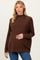 woman wearing a brown oversized maternity sweater and holding her baby bump